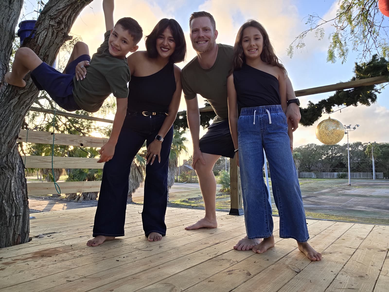 Nate and Waldina Bigbee with their two kids on a deck at sunset